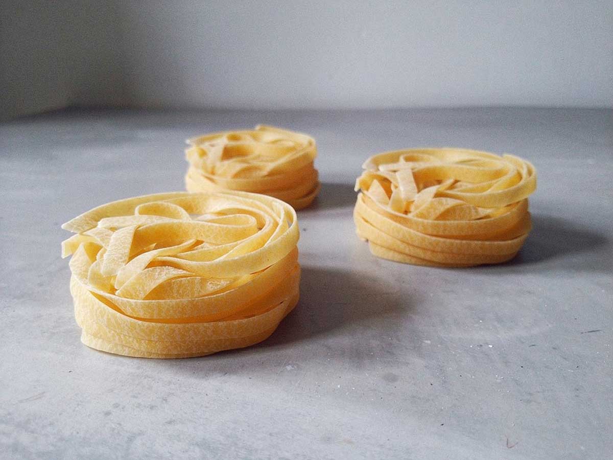 3 bundels gedrogode tagliatelle, klaar om gekookte te worden.