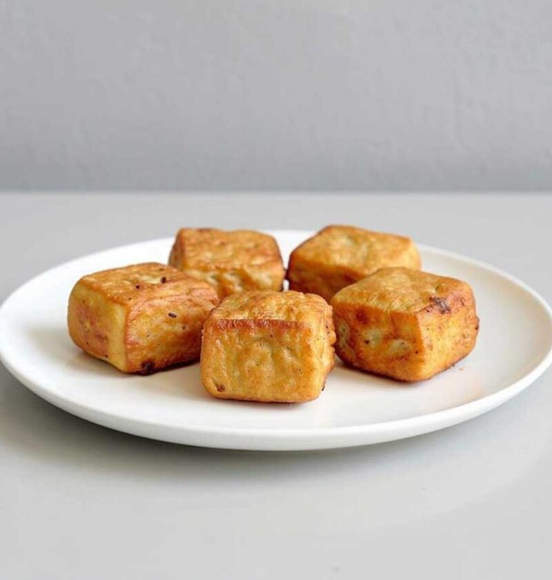 5 stukjes tahu goreng op een wit bordje.