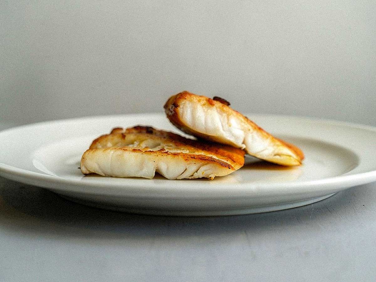 2 gebakken tarbotfilets op een wit bordje.