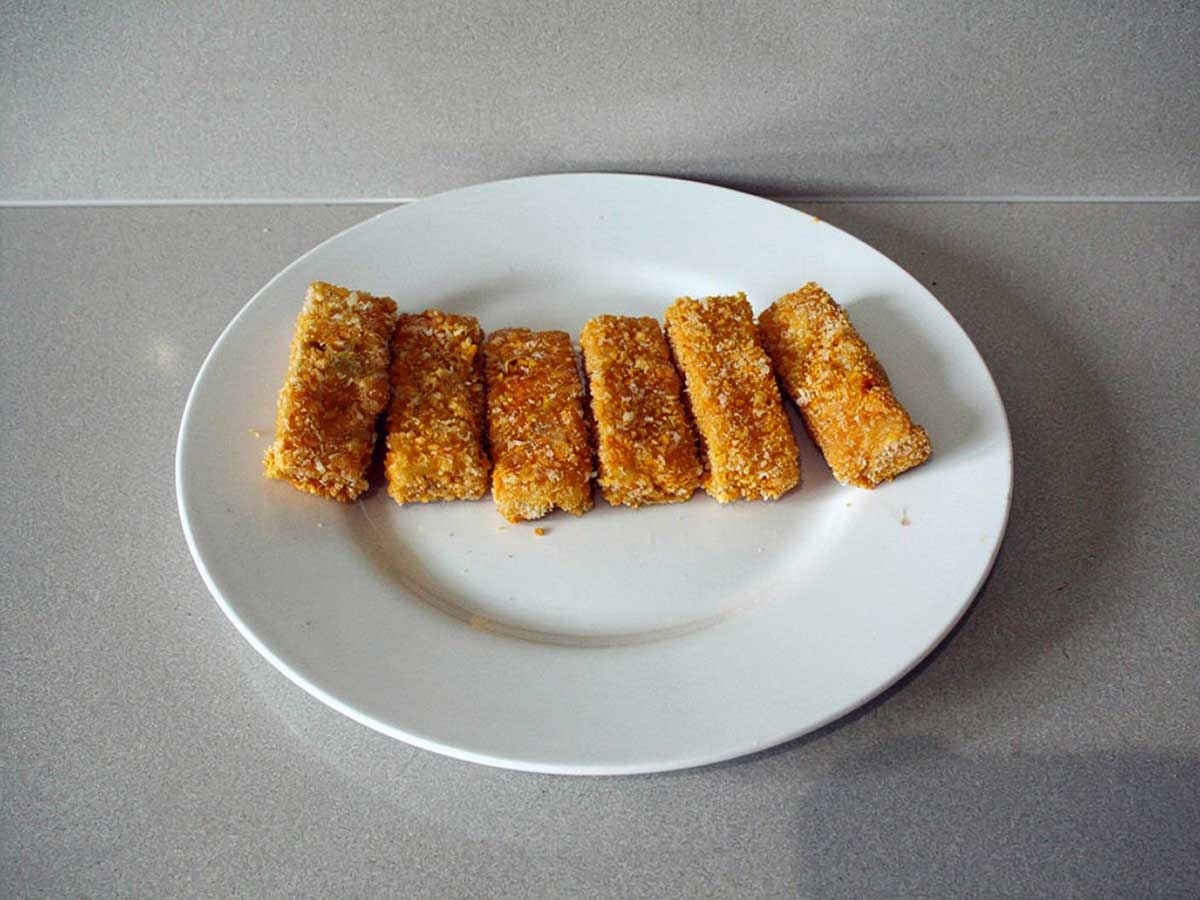 6 vissticks op een wit bordje.