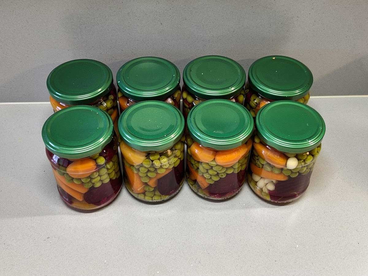 8 glazen potten met ingemaakte groenten, als voorraad.