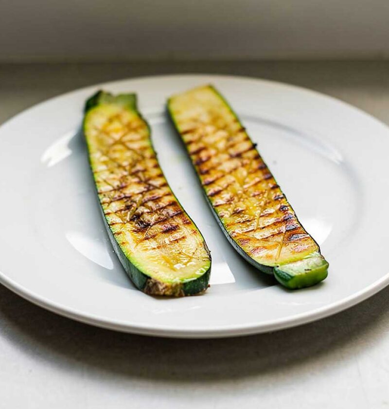 2 in de lengte gesneden plakken courgette, gegrild op de barbecue.
