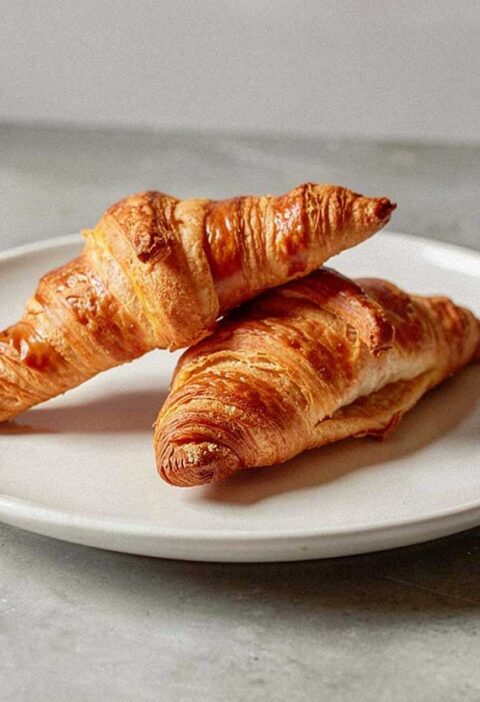 2 vers gebakken croissants op een wit bordje.