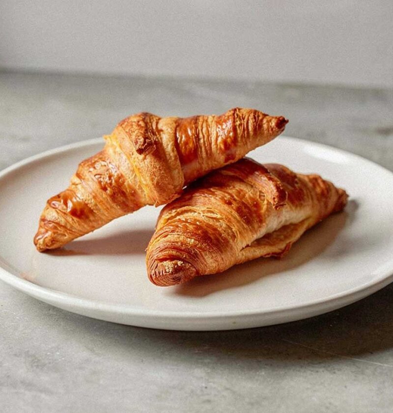 2 vers gebakken croissants op een wit bordje.