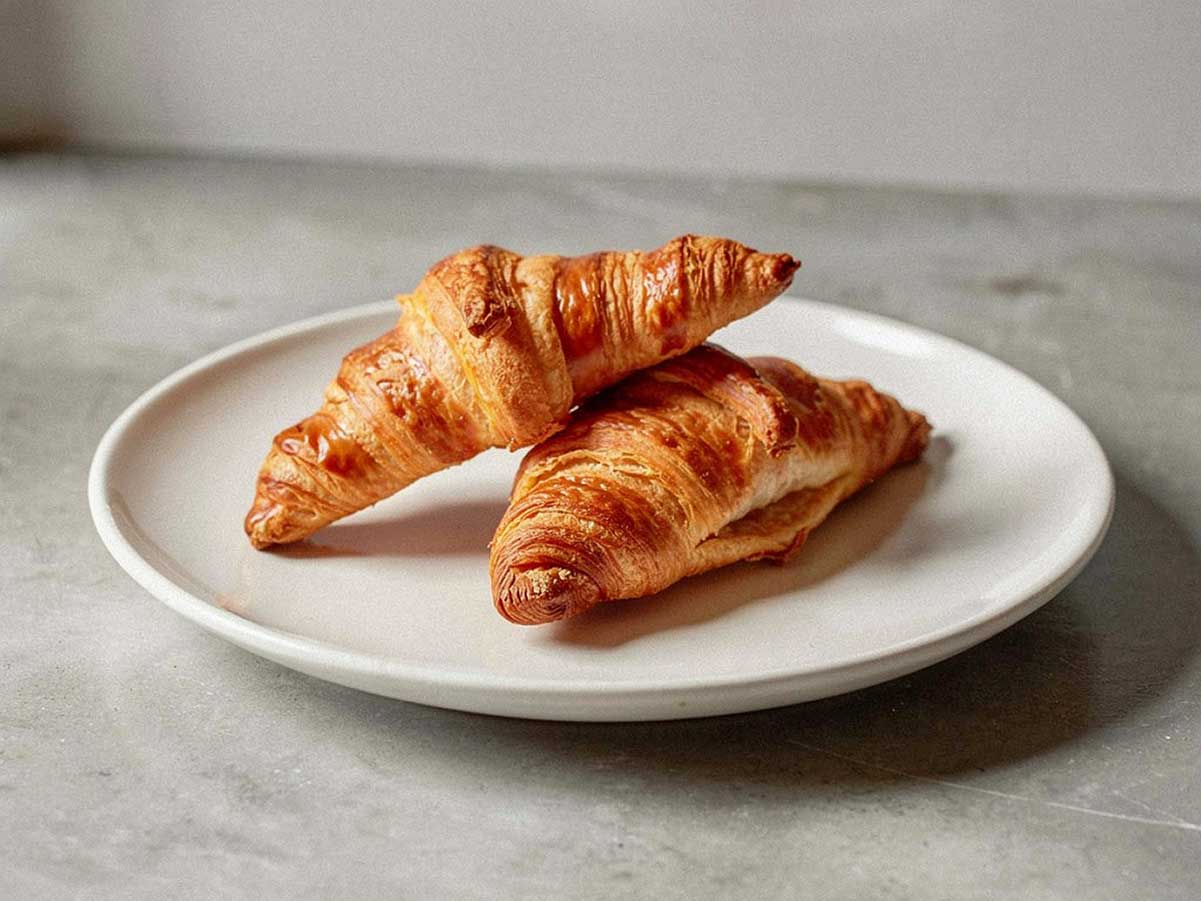 2 vers gebakken croissants op een wit bordje.