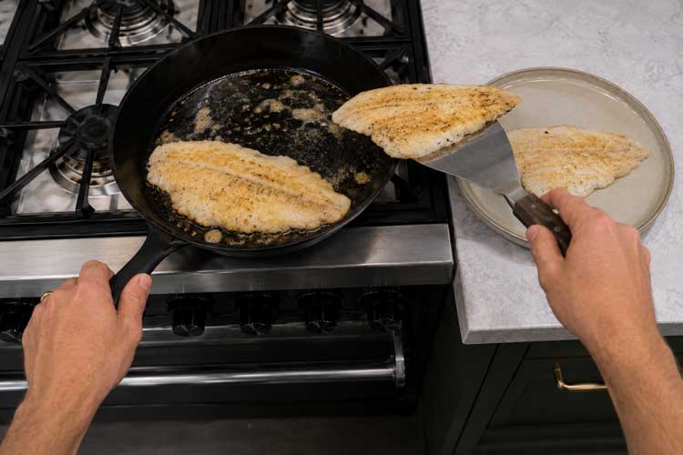 Haal de scholfilets uit de pan en leg ze op een bord