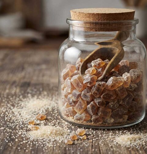 Zelfgemaakte bruine kandijsuiker in een glazen weckpot op een houten tafel
