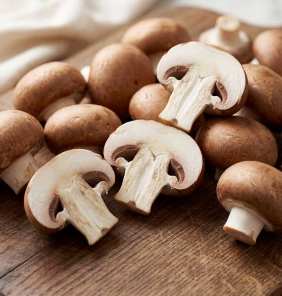 Hele en doormidden gesneden kastanjechampignons wachten om gebakken te worden.