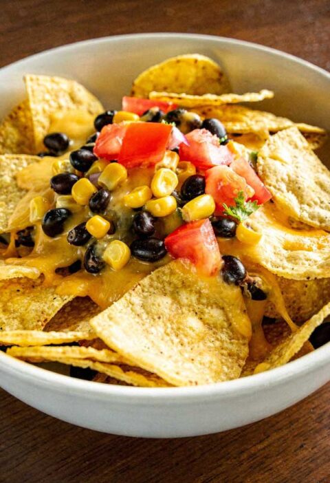 Nachos met kaas, maïs, tomaat en zwarte bonen.