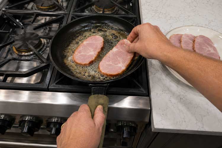 Plakken casselerrib in een gietijzeren pan leggen met schuimende boter