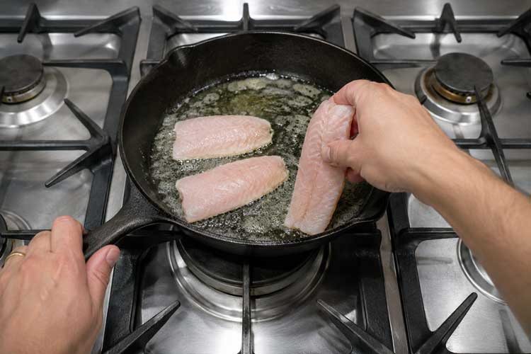 Zodra de boter is gesmolten en licht begint te bruisen, leg je de filets voorzichtig in de pan