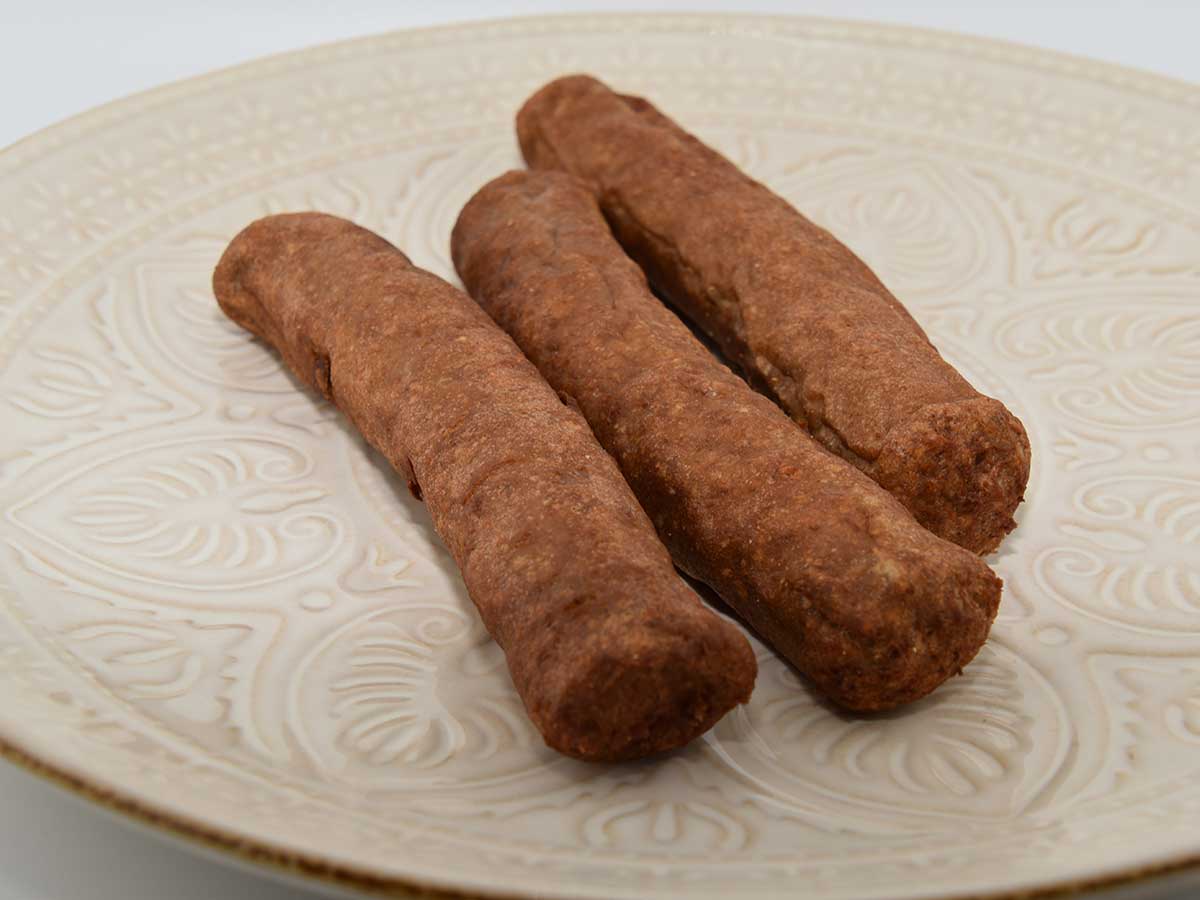 3 gefrituurde frikandellen op een bord.