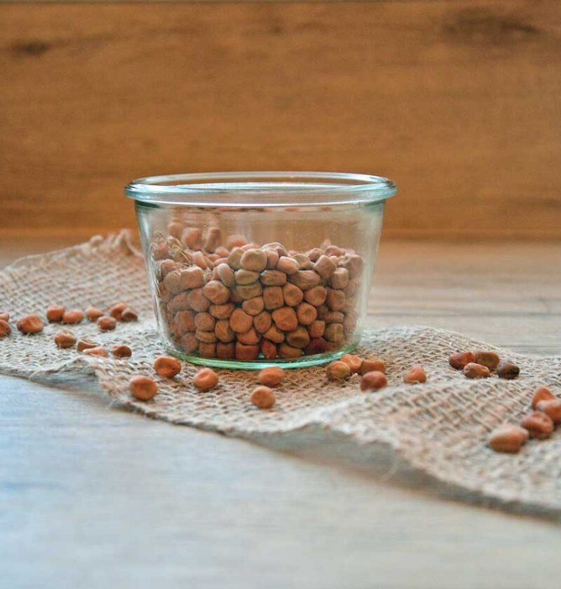 Gedroogde kapucijners in een glazen schaaltje op een soort loper.