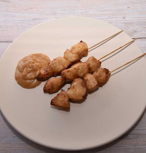 3 gebakken kipsaté op een bord, met zelfgemaakte pindasaus.