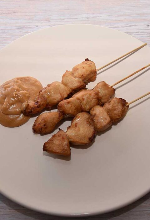 3 gebakken kipsaté op een bord, met zelfgemaakte pindasaus.