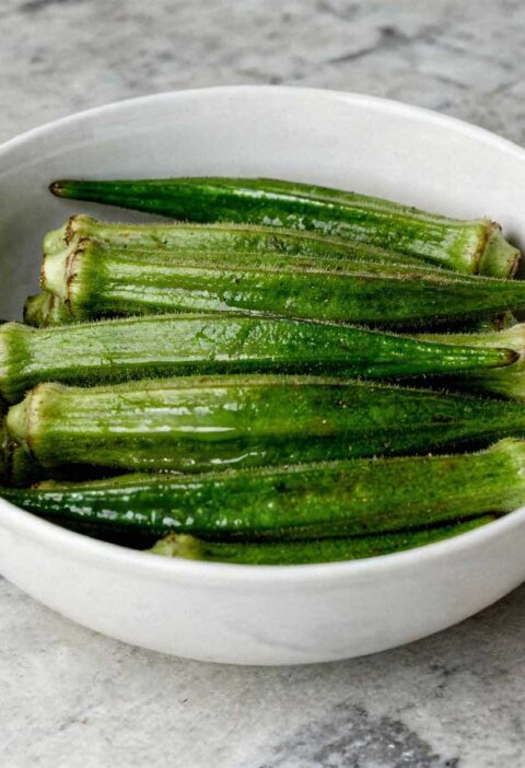 Een wit schaaltje gevuld met hele gekookte groene okra's.