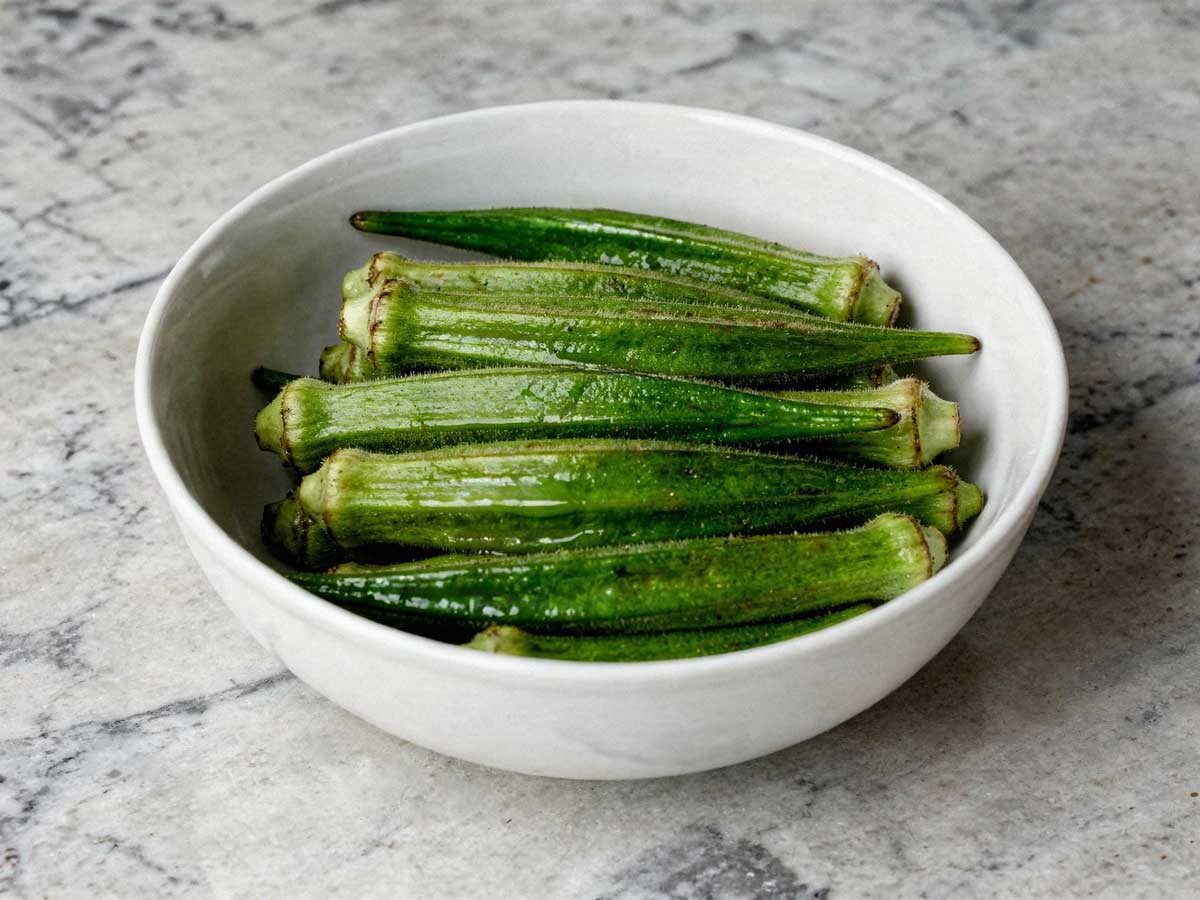 Een wit schaaltje gevuld met hele gekookte groene okra's.