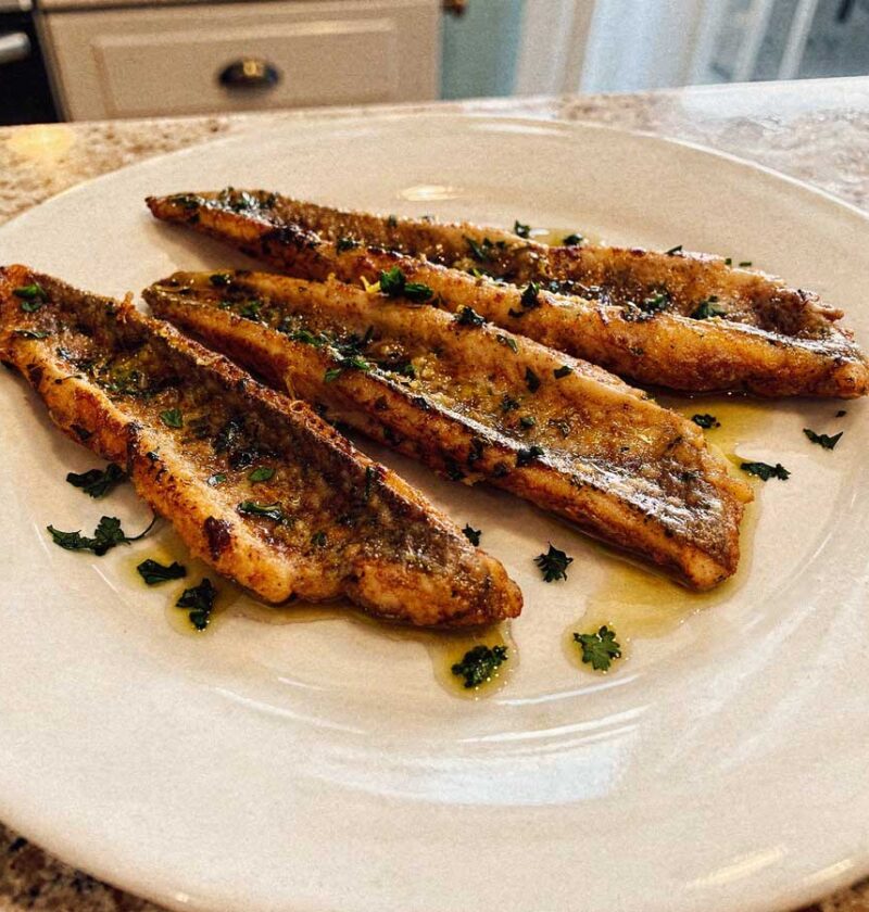 Drie gebakken pietermanfilets op een wit bord