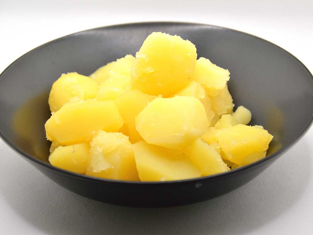 Een donker schaaltje met daarin gekookte aardappelen