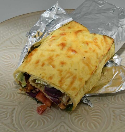 Een gevulde eierwrap, deels nog gewikkeld in alluminumfolie.