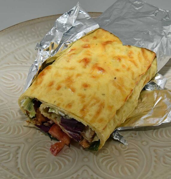 Een gevulde eierwrap, deels nog gewikkeld in alluminumfolie.