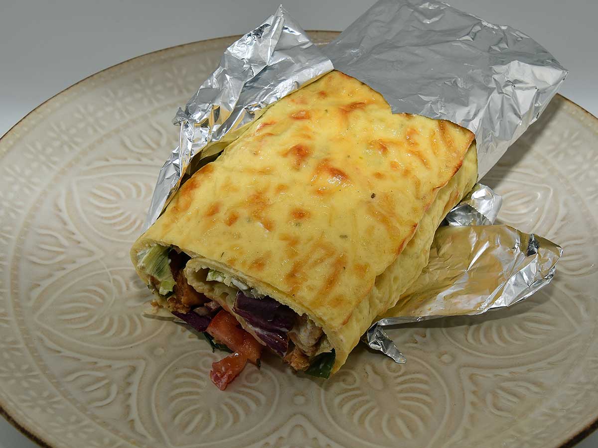 Een gevulde eierwrap, deels nog gewikkeld in alluminumfolie.