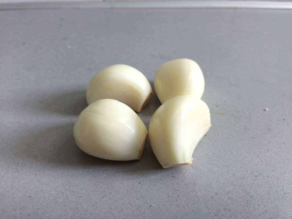 4 schoongemaakte knoflookteentjes. Hoeveel zullen ze wegen?