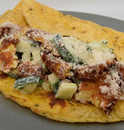 Een bord met daarop röstirondjessalade op een omelet.