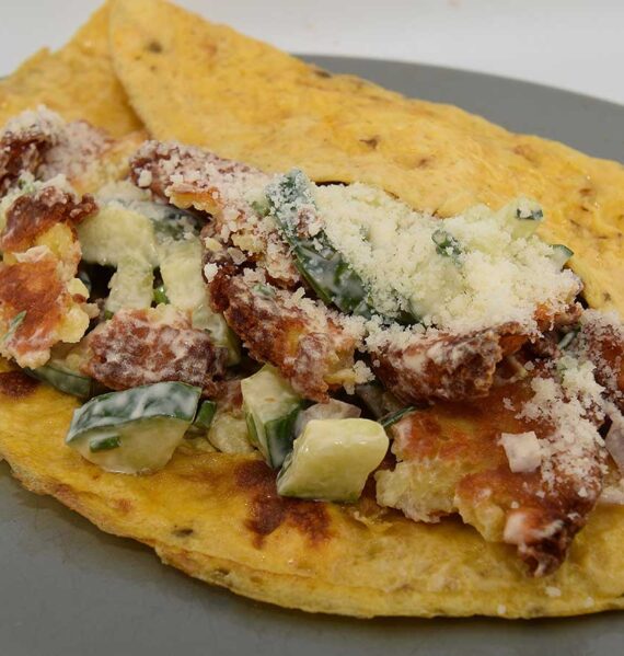 Een bord met daarop röstirondjessalade op een omelet.