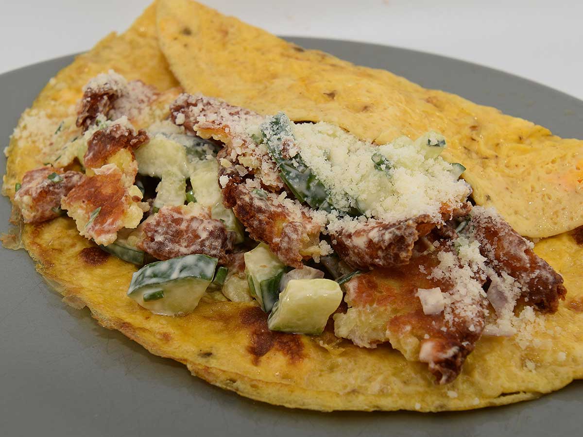 Een bord met daarop röstirondjessalade op een omelet.