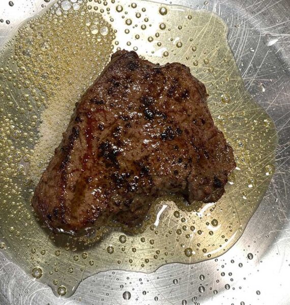 Een perfect dichtsgeschroeide biefstuk in een koekenpan.