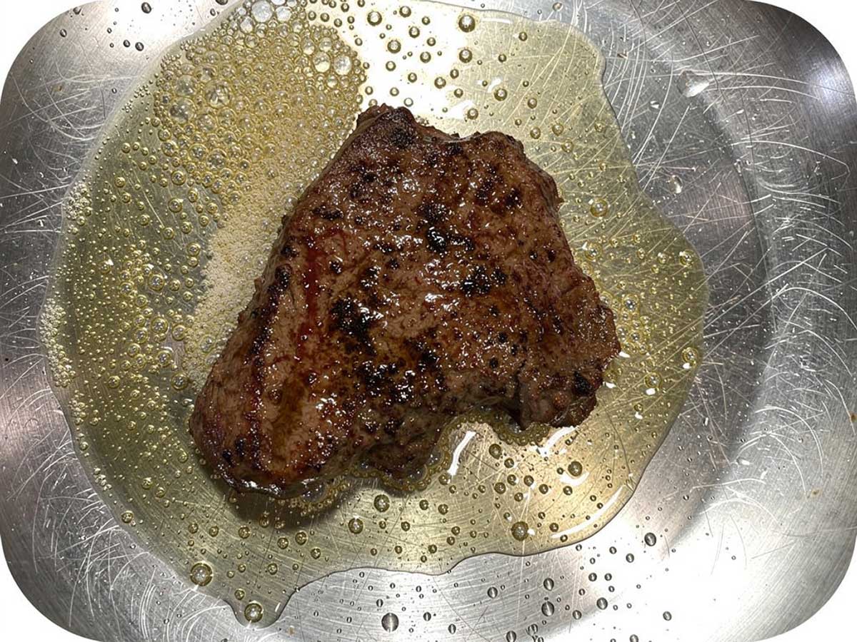 Een perfect dichtsgeschroeide biefstuk in een koekenpan.