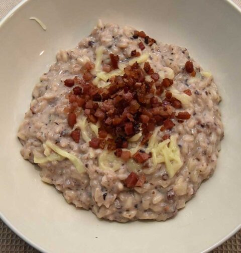 Een bord met Risotto met radicchio en spek.